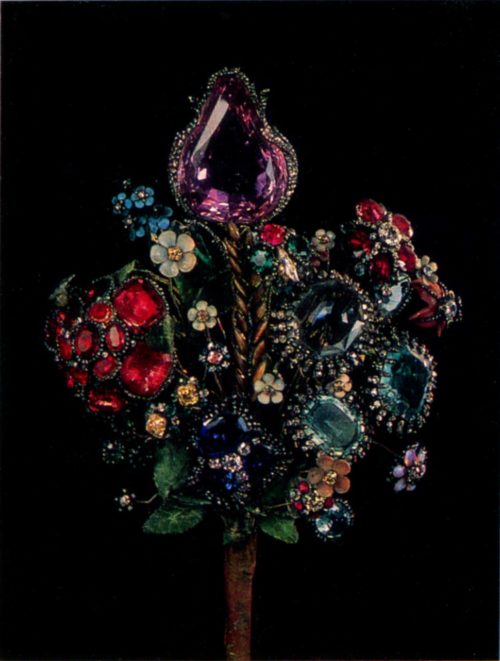 Bouquet of amethyst, rubies, beryls, emeralds, and sapphires bordered with brilliant and rose-cut diamonds, on copper stalks with leaves made of dyed fabric Height 29 cm Russia, St. Petersburg, Jeremie Pauzier. 1740s The Hermitage, Leningrad The highlight of this bouquet is its magnificent tulip formed by a large amethyst in a setting studded with diamonds. Equally splendid is the rose.made of thirteen rubies, next to which beryl asters sparkle, whereas the centre is occupied by ears of wheat made of tiger’s eye. The bouquet also contains enamelled flowers.