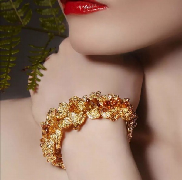 AUTUMN FILE. A bracelet inspired by the enchanting beauty of autumn fall, embedded in jeweled, unique leaf shapes. Each leaf has been hand carved to depict the wriggling shapes of the dried leaves as they float and fall on top of each other. The ensemble of leaves is further enhanced by the beauty of Natural Fancy Color Diamond Beads