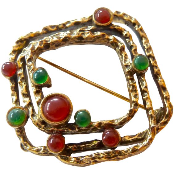 Abstract brooch with an open layered square pattern embellished with crimson and green cabochons.