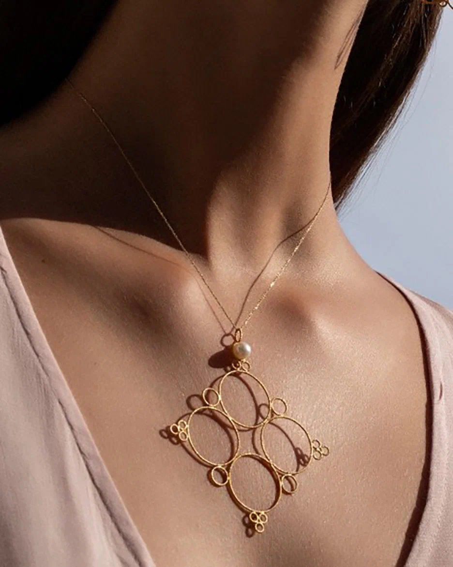 Cross pendant in the form of circles with a pearl