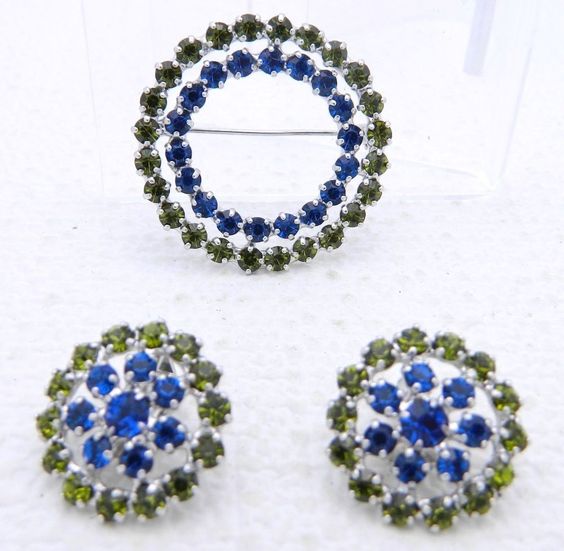 Brooch and earrings with blue green rhinestones.