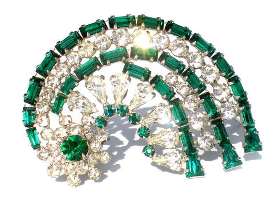 Round brooch with green crystals.
