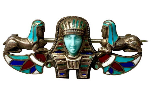 Art Deco silver brooch with carved turquoise pharaoh flanked by sphinxes, decorated with enamel, circa 1920.