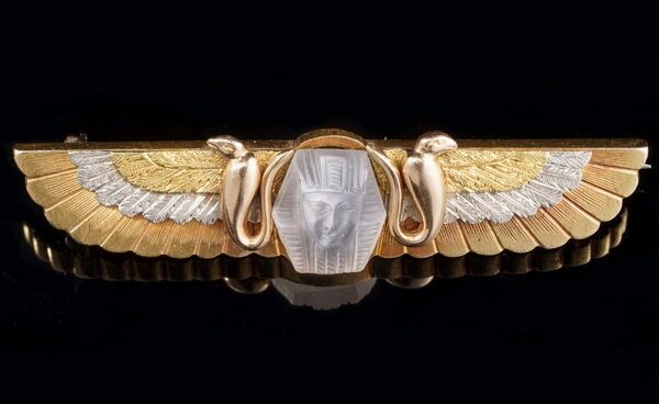 Gold winged brooch with a carved image of a moonstone pharaoh surrounded by snakes, circa 1860.
