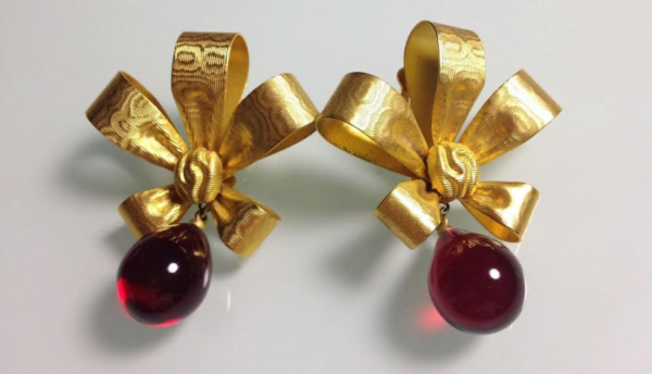 Vintage clips with bows. Decorated with drop shaped cabochons in the Gripoix style in red. The clips are made of gold jewelry alloy with embossing.