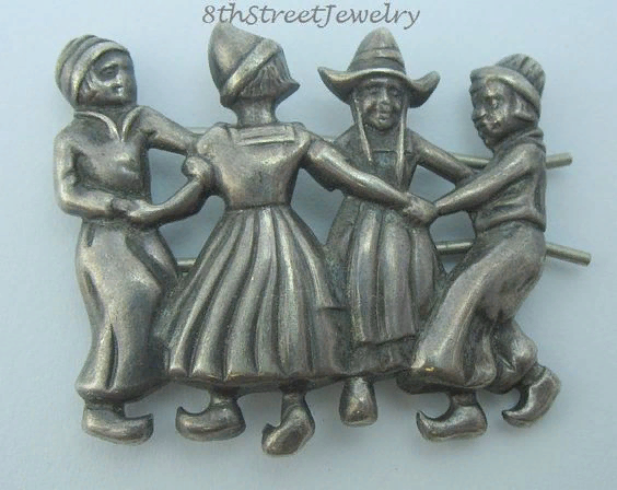 Brooch in the form of people dancing in a round dance.