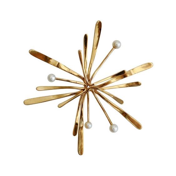 Gilded star shaped brooch with pearls.