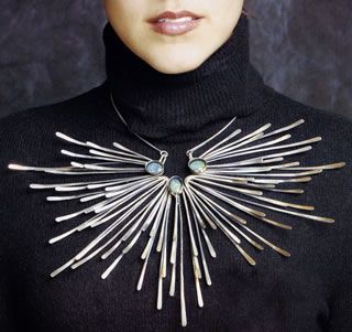 Large silver necklace in the shape of sun rays.