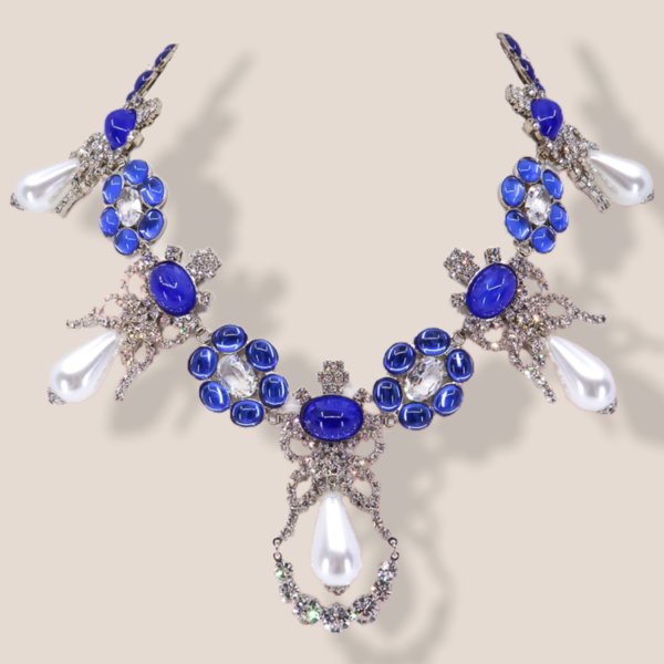 This silver tone necklace features a stunning design with three dimensional hanging elements.