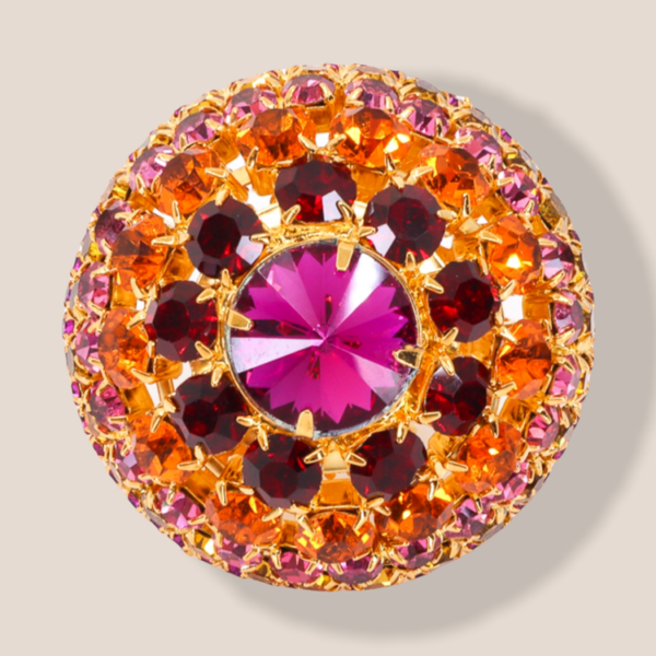 gold tone ring features a large circular structure with set in, pink and gold crystals out of vintage glass.