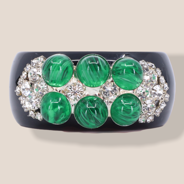 statement bracelet features a beautiful emerald imitation design.