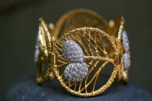 A chic wide gold bracelet with cedar cones.