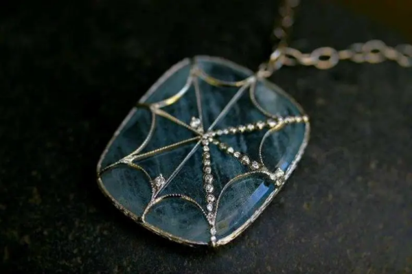 Aquamarine pendant with spider web.