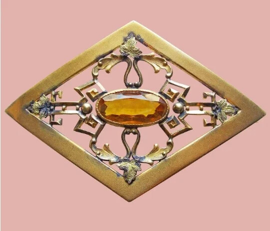 Copper brooch with amber.
