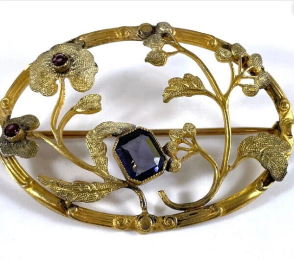 Oval brooch with sapphire and flowers.