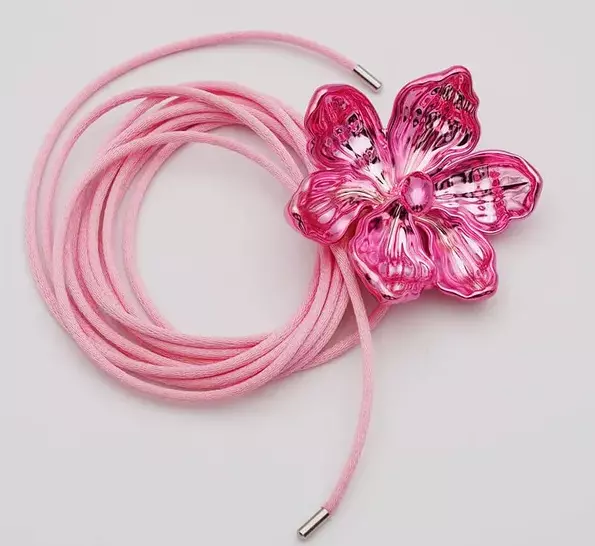 Pink necklace on a cord with a flower.