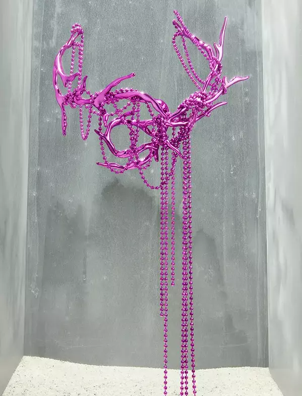Pink necklace with chain and horns.