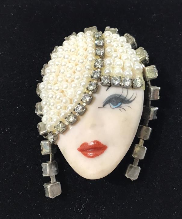 Porcelain face with pearls and rhinestones.